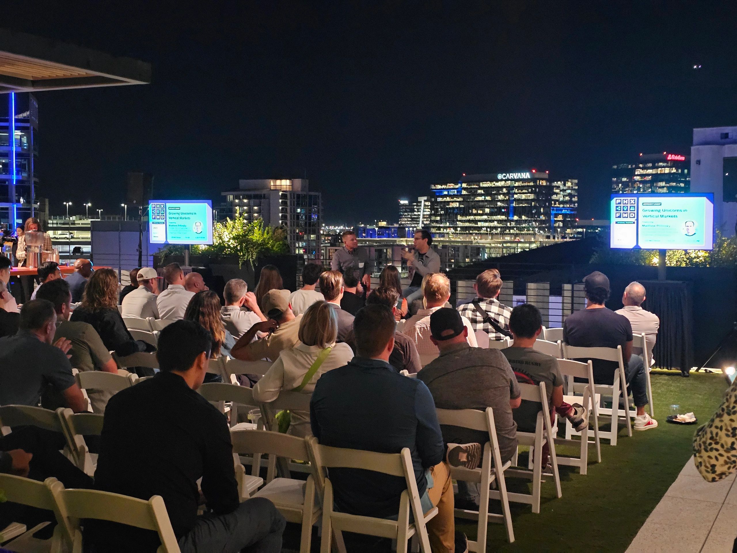 Rooftop outdoor corporate event with city skyline at night