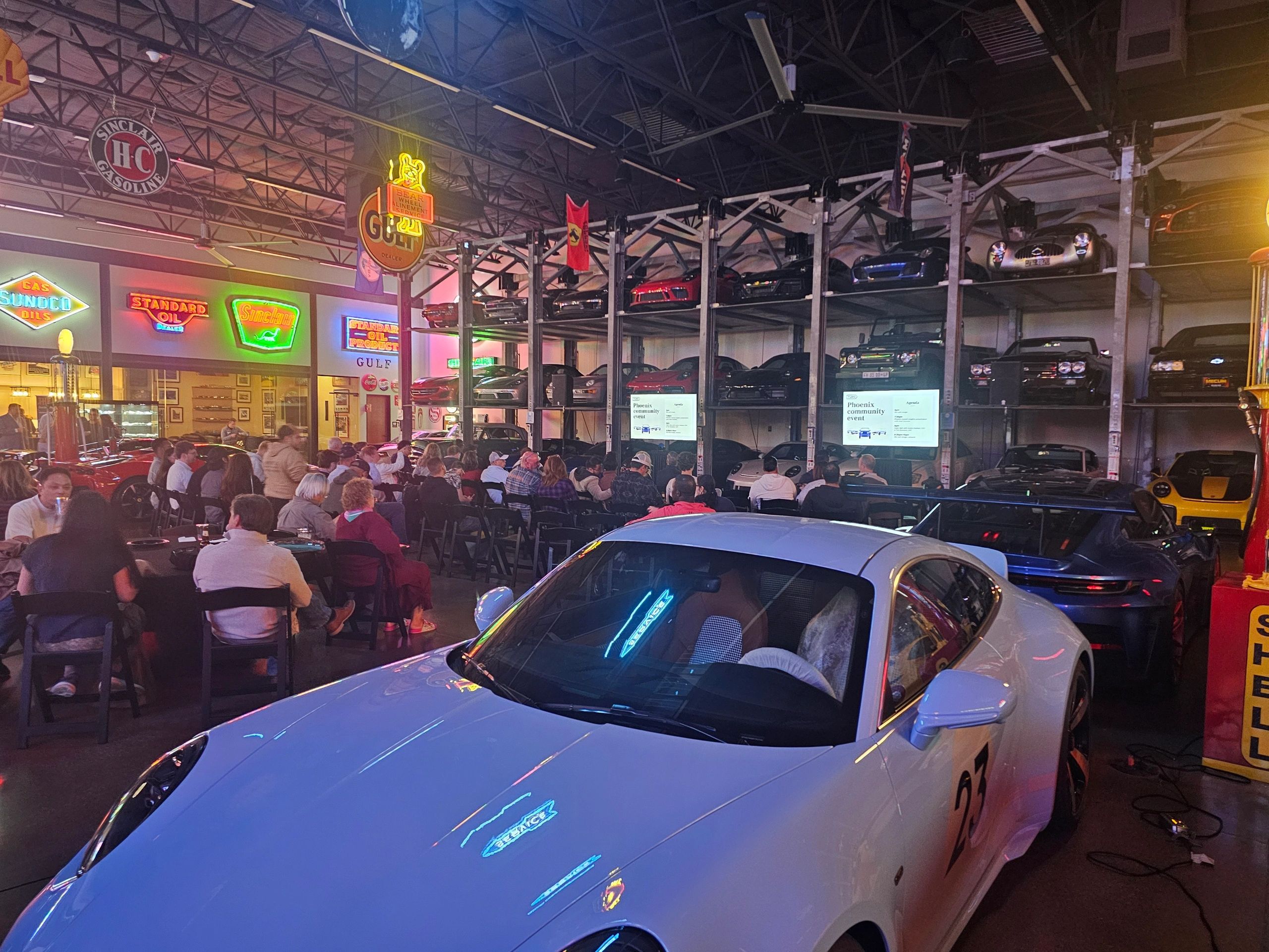Automotive museum car show with crowds and neon signs